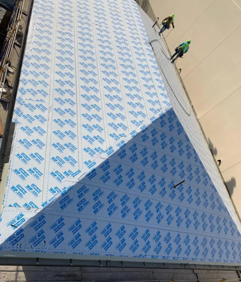 Professional roofers installing underlayment on a metal roof in Westfield